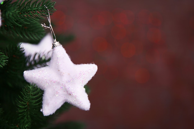 Albero di Natale con decorazioni su superficie luminosa, primo piano