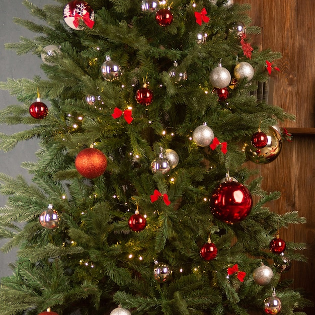 Albero di Natale con ghirlanda sullo sfondo di una parete in legno