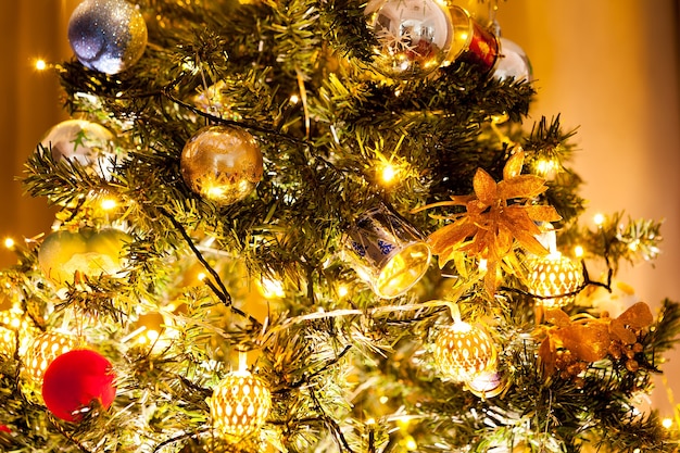 Albero di Natale con ghirlande e decorazioni in casa. Albero verde decorativo e festoso