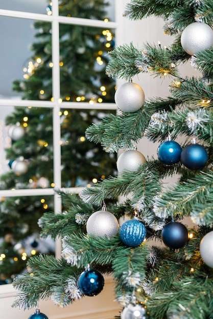 Albero di Natale con giocattoli blu e argento Albero di Natale decorato a festa con ghirlande Simbolo del nuovo anno