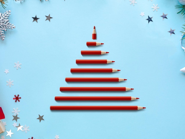 Albero di Natale con matite di legno rosse su sfondo blu Giorno di Natale Albero di Natale e illustrazione di celebrazione
