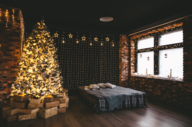 Albero di Natale con molte lampadine e decorazioni nere dorate
