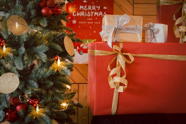 Albero di Natale con regali di Natale leggeri e avvolti con nella stanza