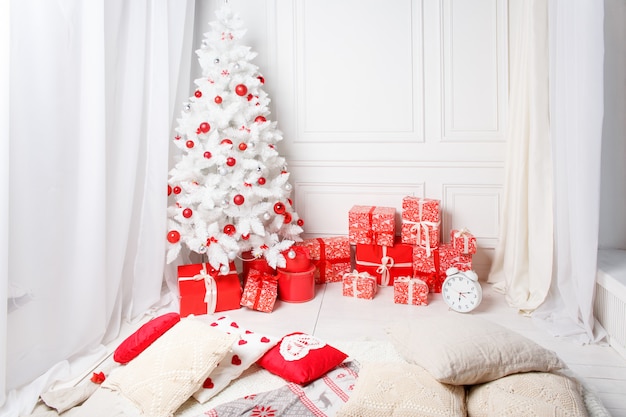 Albero di Natale con regali sotto nel salotto bianco