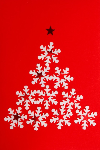 Albero di Natale creativo dalla cartolina dei fiocchi di neve su sfondo rosso