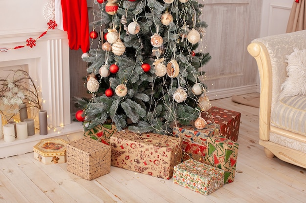 Albero di Natale decorato con doni, caminetto e candele