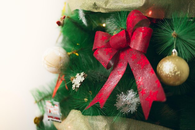 Albero di Natale decorato con fiocchi di palline e luci su sfondo bianco