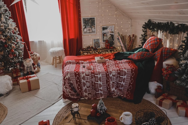 Albero di Natale decorato con regali all'interno della camera da letto classica bianca con ghirlanda scintillante per le vacanze di Capodanno.