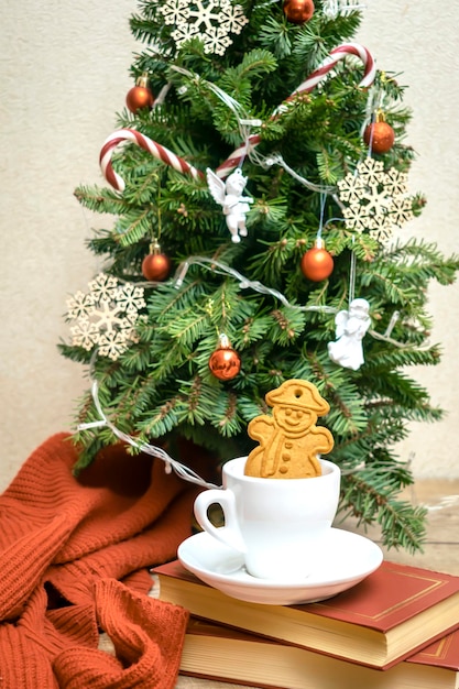 Albero di Natale decorato con una tazza di tè, caffè e biscotti allo zenzero, palle, fiocchi di neve, bastoncini di zucchero, angeli, luci, ghirlanda, decorazioni festive, natale, anno nuovo, decorazioni, vacanze invernali, concetto