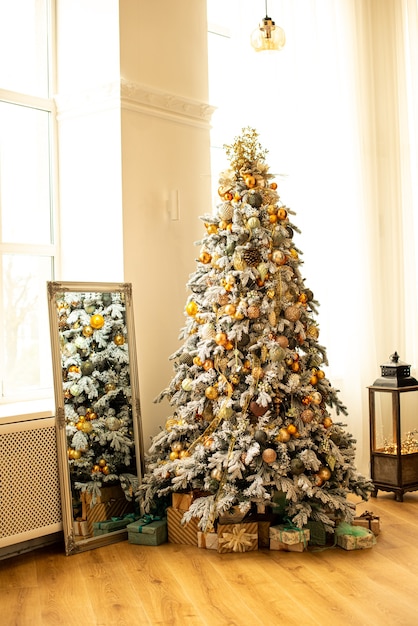 Albero di Natale decorato in camera. Vicino a una scatola diversa con regali per il nuovo anno