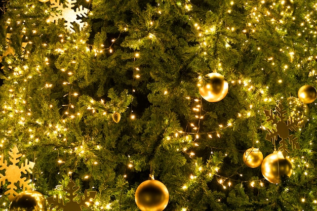 Albero di Natale del primo piano con la sfera della decorazione, della luce e dell'oro alla notte nelle vacanze di natale e di nuovo anno.