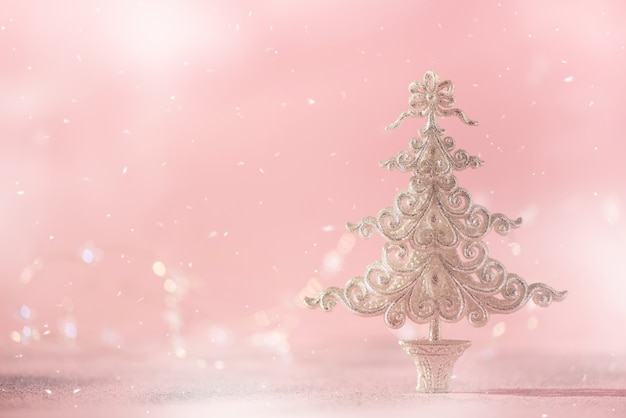 Albero di Natale di scintillio d&#39;argento su fondo rosa con il bokeh delle luci, spazio della copia.