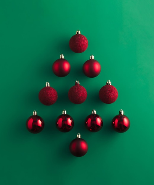 Albero di Natale fatto di decorazioni rosse su sfondo verde tavolo Flat lay Happy New Year