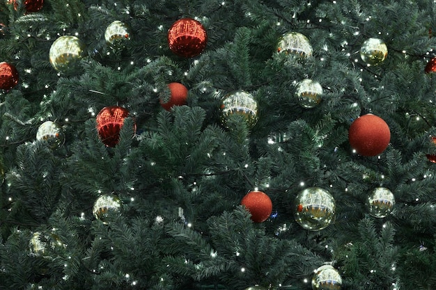 Albero di Natale festivo di Capodanno decorato con palle di Natale gialle rosse con ghirlande di luci