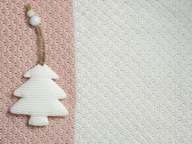 Albero di Natale in tessuto giocattolo di Natale fatto a mano sullo sfondo di un plaid o un maglione lavorato a maglia.