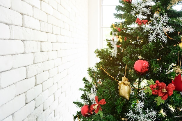 Albero di Natale in verde con decorazioni rosse nella stanza.