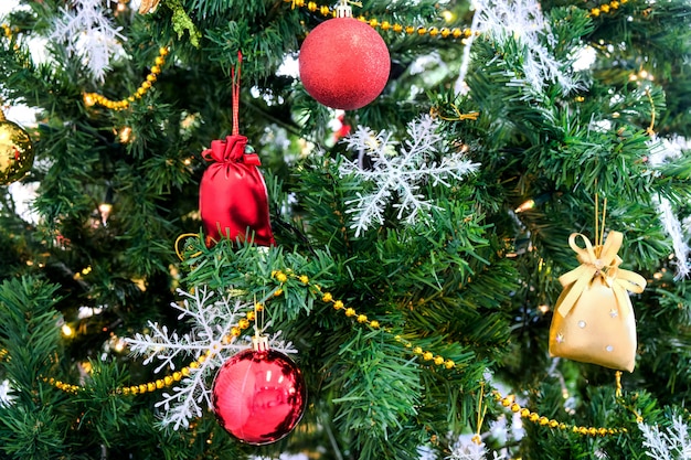 Albero di Natale in verde con decorazioni rosse nella stanza.