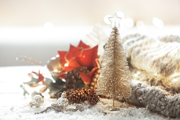 Albero di Natale lucido decorativo su sfondo sfocato di dettagli di arredamento con bokeh.