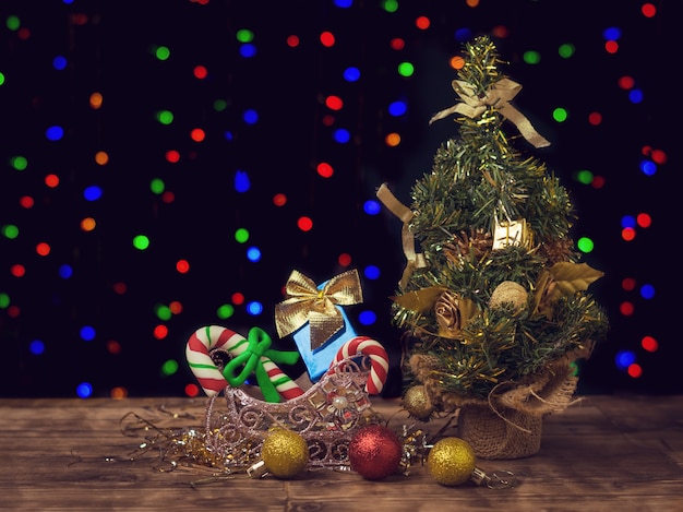 Albero di Natale, regali e decorazioni sul pavimento in legno. buon Natale