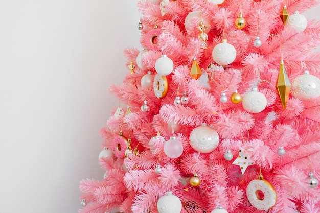 Albero di Natale rosa e decorazioni natalizie colore bianco e oro. Sfondo di Natale. Felice anno nuovo e Natale concetto di Natale.