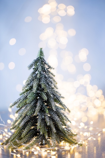 Albero di Natale su sfondo blu bokeh.