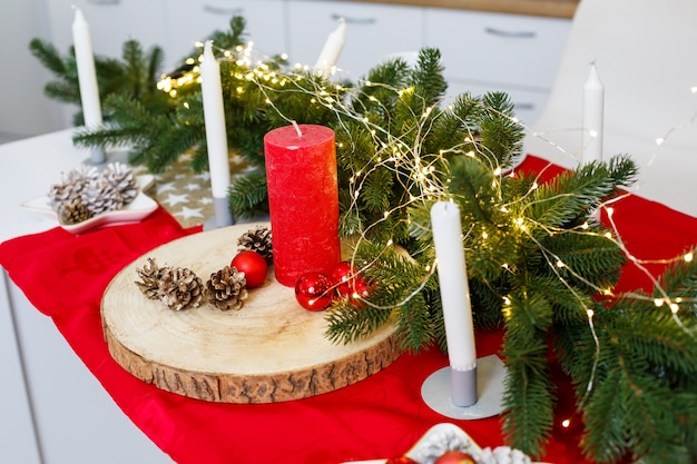 Albero di Natale verde, decorato con palline, decorazioni natalizie, ghirlande gialle. Decorazioni di Capodanno in cucina. Nuovo anno. Decorazioni in casa per Natale.