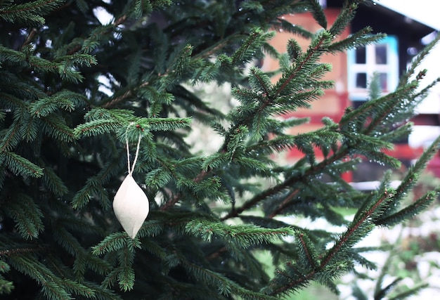 Albero di Natale vicino alla casa con giocattoli di carta fatti a mano