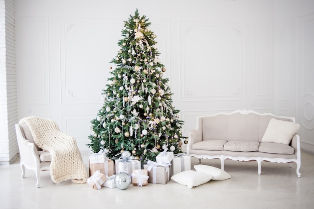 Albero interno del nuovo anno decorato stanza classica di Natale decorato. Albero di Natale con decorazioni in oro. Interior design in stile classico bianco moderno