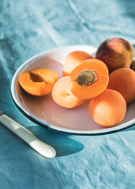 Albicocche mature e foglie di albicocca in una ciotola su un tavolo di legno Frutta fresca dal giardino di casa Cibo sano