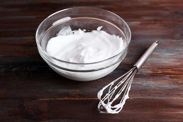 Albumi montati a neve per crema su fondo di legno