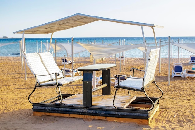 Alcova aperta bar caffetteria terrazza con tavolo e sedie per i visitatori sulla spiaggia di sabbia tropicale mare resortVacanze estive in una calda giornata di sole all'aperto sotto il sole