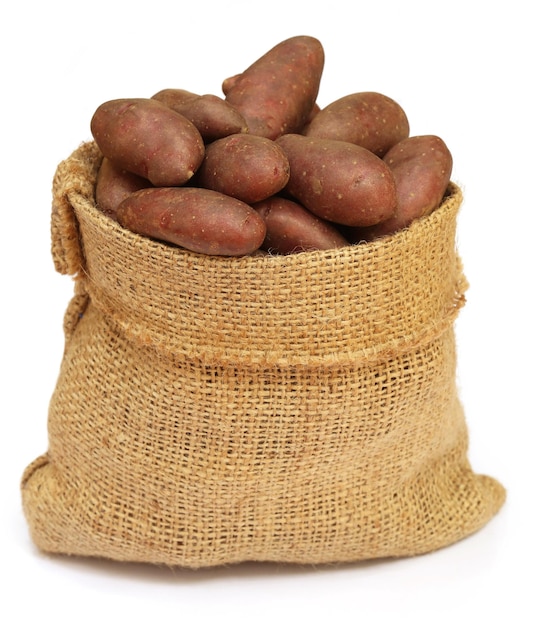 Alcune patate rosse in un sacco su sfondo bianco