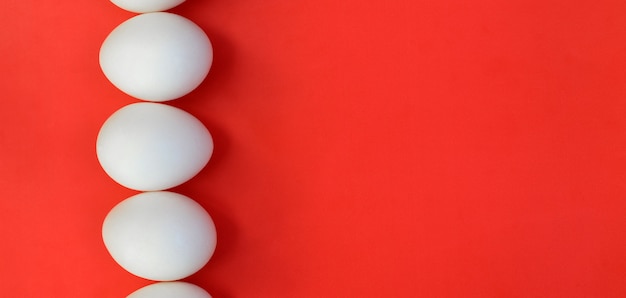 Alcune uova bianche su uno sfondo rosso brillante