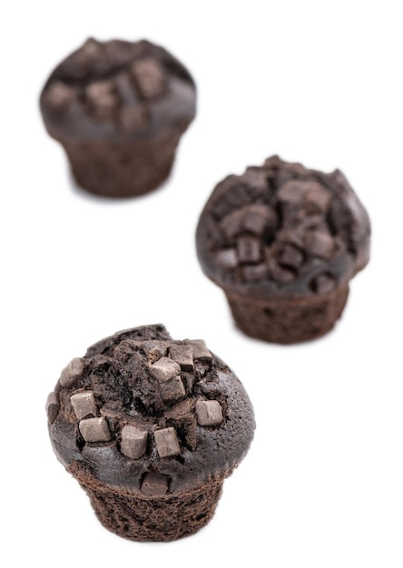 Alcuni muffin al cioccolato isolati su fuoco selettivo bianco