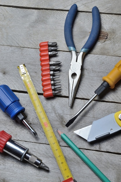 alcuni strumenti di riparazione domestica giacciono su uno sfondo di legno. avvicinamento.