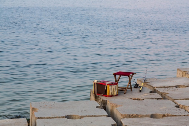 Alessandria Egitto Pescatori rod una sedia e una borsa sulla passeggiata senza persone Minimalismo