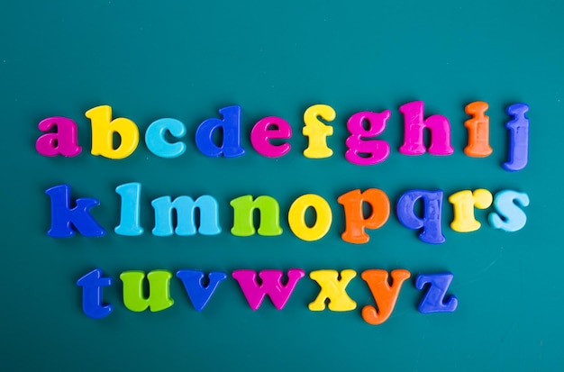 Alfabeti di plastica colorati su sfondo blu