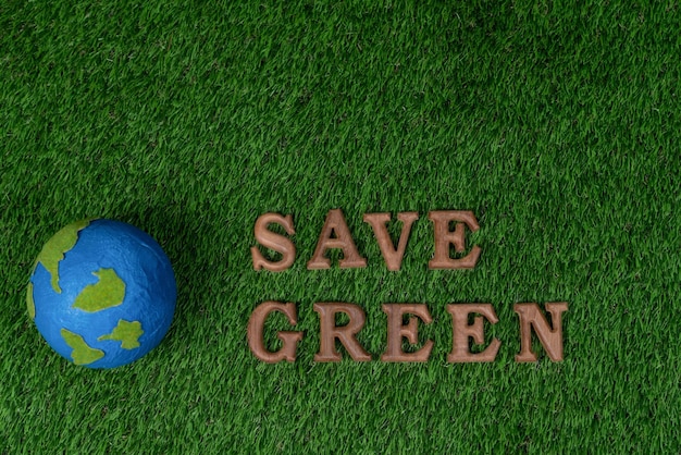 Alfabeto in legno organizzato in una campagna di consapevolezza ecologica con il design dell'icona ECO sullo sfondo dell'erba verde biofilica per promuovere la protezione ambientale per un futuro più verde e sostenibile Gyre
