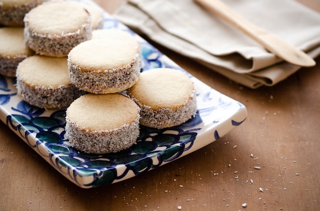 Alfajores di amido di mais con caramello al latte e cocco su vassoio fiorito