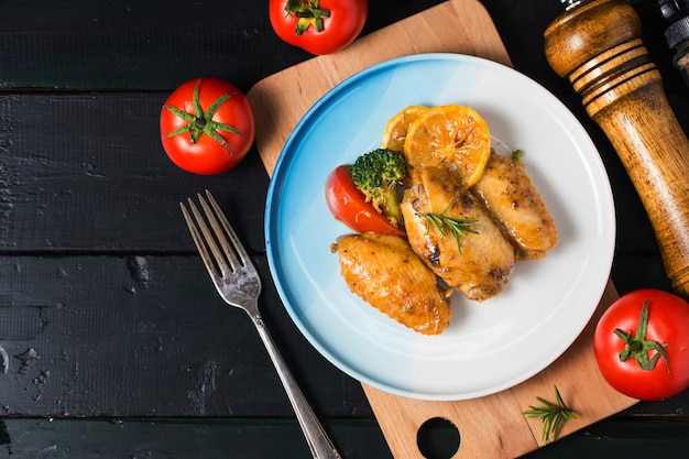 Ali di pollo alla griglia con verdure ed erbe aromatiche