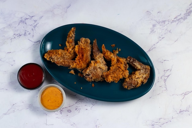 Ali di pollo croccanti con salsa di pomodoro e salsa di maionese isolate sul tagliere vista laterale del fastfood