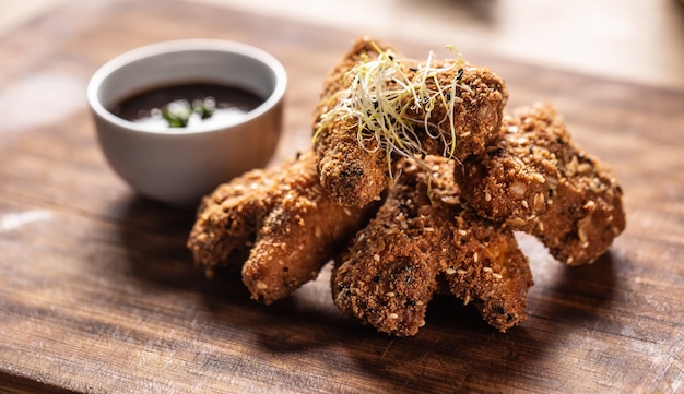 Ali di pollo fritte sul bordo di legno del macellaio.