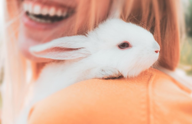 Alice nel paese delle meraviglie. Donna che tiene coniglio lanuginoso sveglio, primo piano. L'amicizia con il coniglietto di Pasqua.