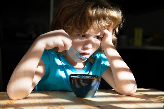 Alimentazione dei bambini. Abitudini alimentari sane. Cibo casalingo per bambini. Il ragazzo fa colazione in cucina.