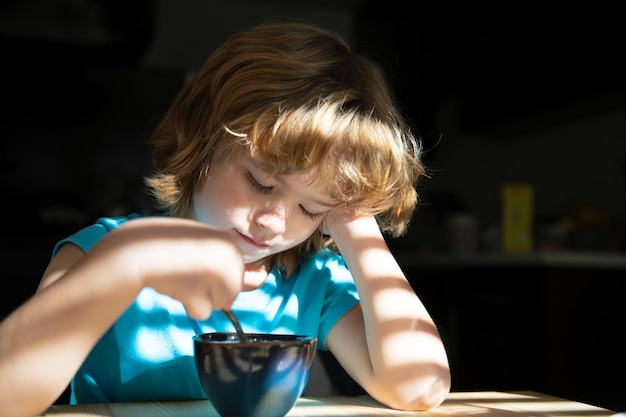 Alimentazione e abitudini alimentari sane per i bambini Cibo per la casa Il ragazzo fa colazione in cucina