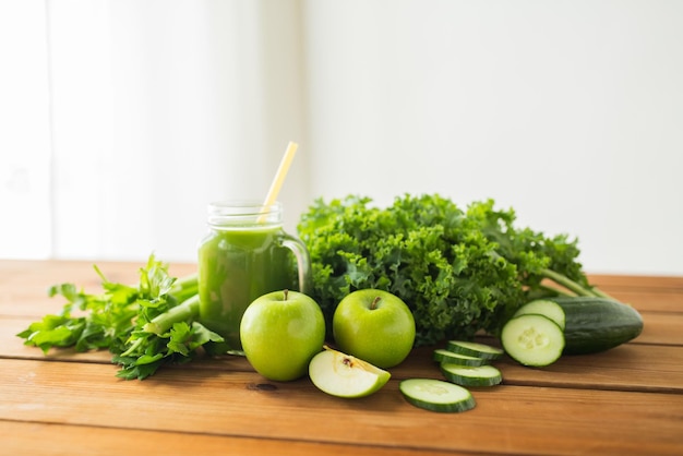 alimentazione sana, cibo, dieta e concetto vegetariano - primo piano di brocca di vetro con succo verde, frutta e verdura su tavola di legno