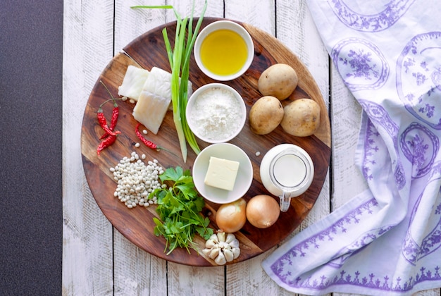 Alimentazione sana e concetto di dieta - cibo naturale sul tavolo. Ingredienti Pesce Fagioli Prezzemolo Cipolla Crema Patate per polpette