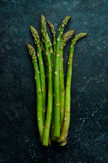 Alimenti biologici Asparagi verdi su un tavolo di pietra nera Su uno sfondo di pietra Vista dall'alto