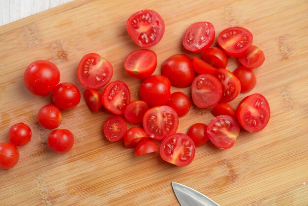 Alimenti di cucina Tomati cherry brillanti tagliati su legno