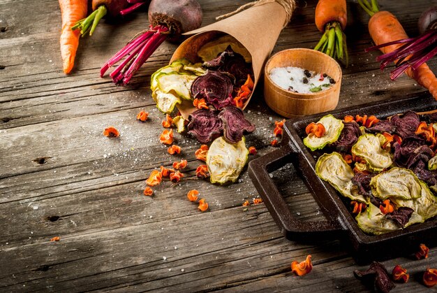 Alimenti dietetici biologici La dieta vegana Verdure Secche Patatine fatte in casa da barbabietole, carote e zucchine. Sul vecchio tavolo di legno rustico, con verdure fresche.